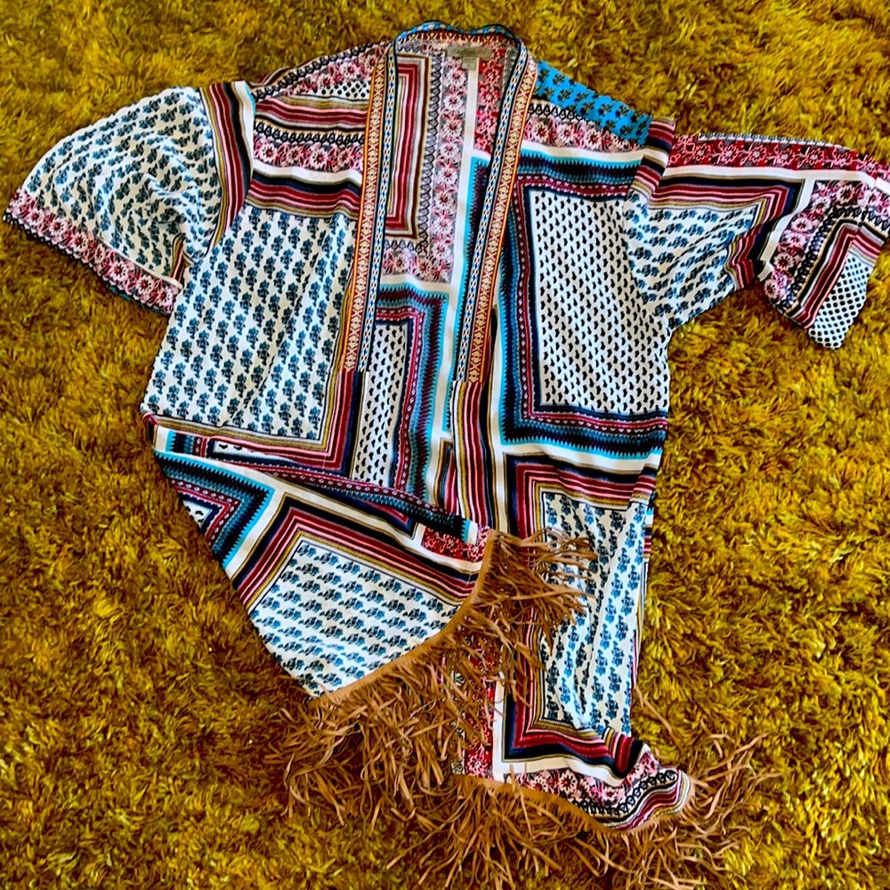 A short sleeves cardigan with fringed bottom.